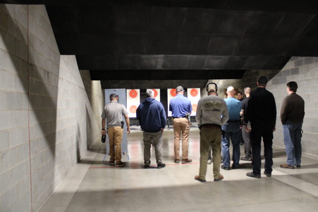 Firearms class group standing on the indoor range at Capitol Range in Youngsville